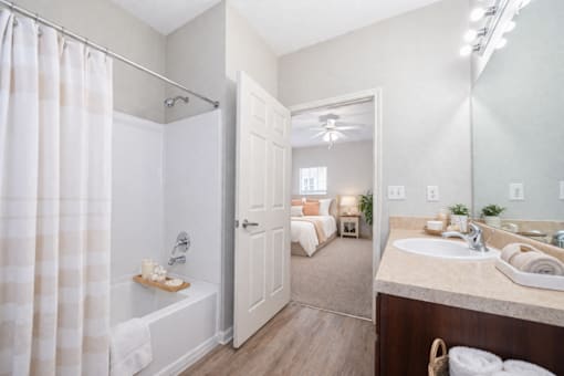 A bathroom with a white shower curtain and a white door.
