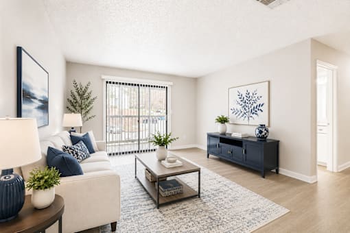 A living room with a white couch, a coffee table, and a painting on the wall.