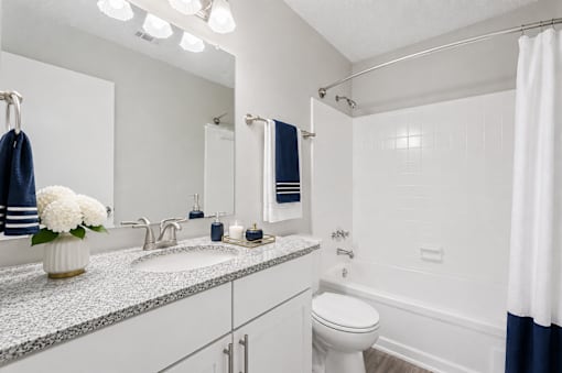 A white bathroom with a toilet, sink, and shower.
