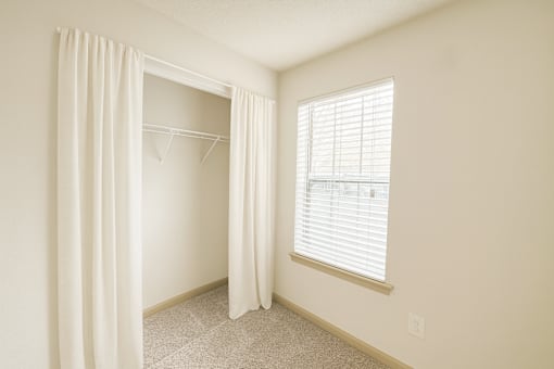 A room with a window and a curtain.