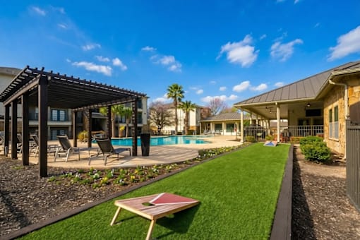 A backyard with a pool and a patio area.