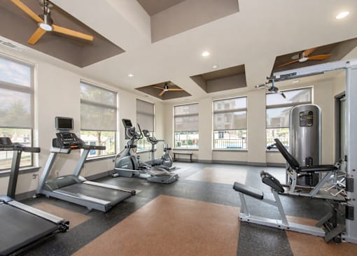 A gym with treadmills, exercise bikes, and weight machines.