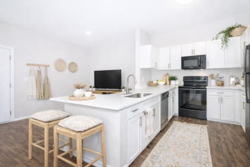A kitchen with white cabinets and a black oven.