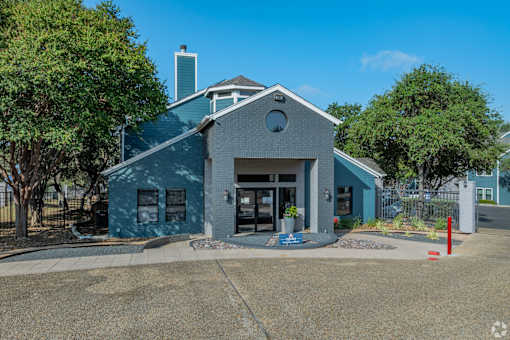 A blue building with a grey roof and a white circle window on the front.