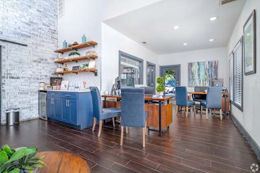 A kitchen with blue chairs and a wooden table.