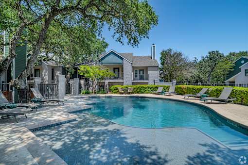A large swimming pool in front of a house.
