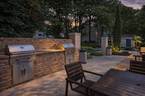 A backyard with a grill and a chair.