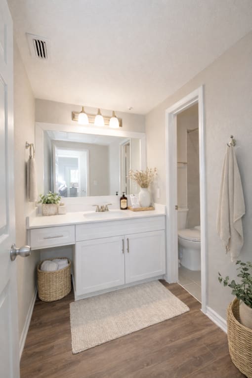 A bathroom with a white cabinet and a mirror above the sink.