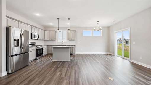 A modern kitchen with stainless steel appliances and wooden flooring.