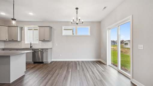 A kitchen with a dining area and a view of the backyard.