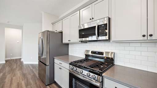 A modern kitchen with stainless steel appliances and white cabinets.
