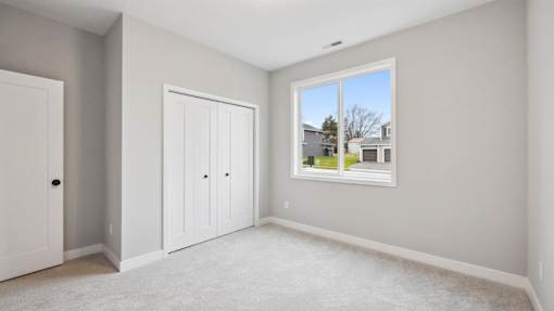 A room with a large window and two doors.