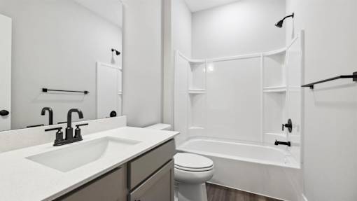 A white bathroom with a toilet, sink, and bathtub.