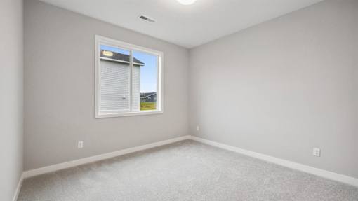 A room with a window and a view of a building outside.