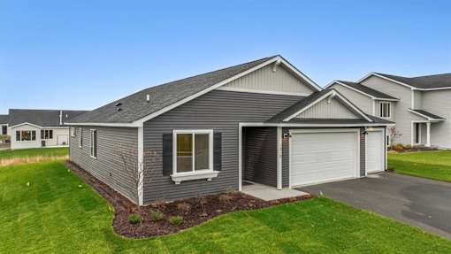 A grey house with a white garage door and a window.