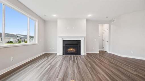 A spacious living room with a fireplace and hardwood floors.