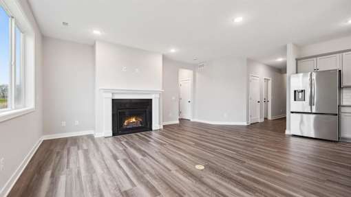 A modern kitchen with a fireplace and wooden floors.