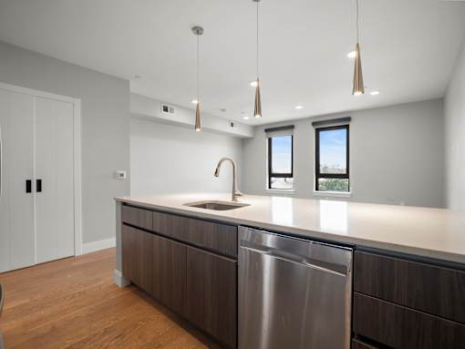 A modern kitchen with a stainless steel dishwasher and wooden cabinets.