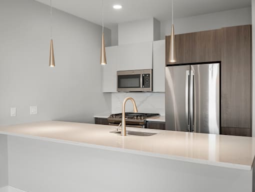 A modern kitchen with a stainless steel refrigerator and a white countertop.