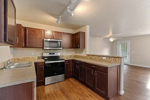 A kitchen with brown cabinets and a stainless steel oven.