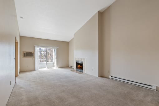empty living room with carpet, fireplace, and sliding door to balcony.