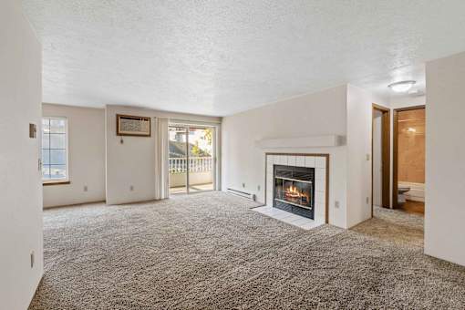 a living room with a fireplace and a door to a balcony