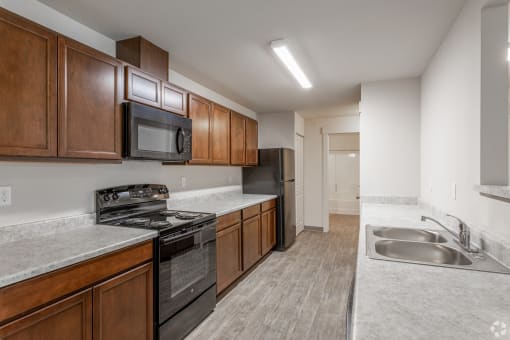 a kitchen with wood cabinets and stainless steel appliances and a sink