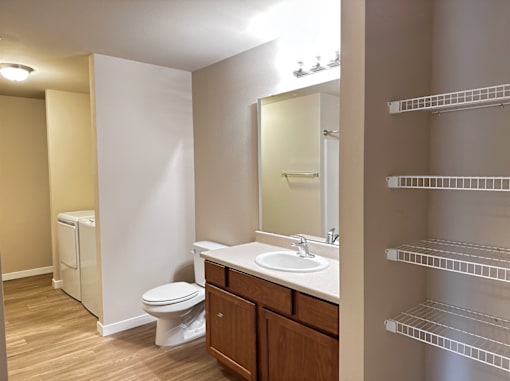 A bathroom with a toilet, sink, and mirror.