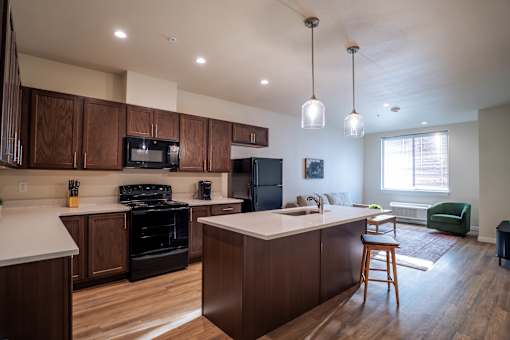 A kitchen with dark wood cabinets and a white countertop.
