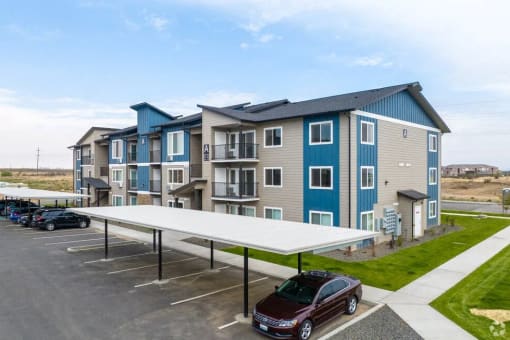 an apartment building with a car parked in a parking lot
