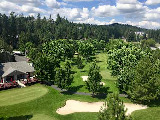 A golf course with a green and a sand trap.