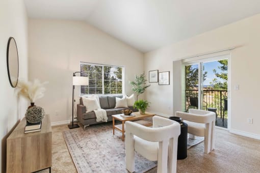 a living room with white furniture and a large window