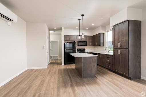 A modern kitchen with wooden floors and cabinets.