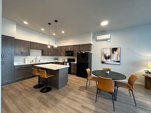 A modern kitchen with a dining table and chairs.