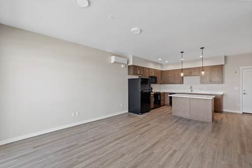 A kitchen with a black refrigerator and a white countertop.