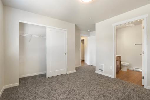 A large, empty room with a carpeted floor and white walls.