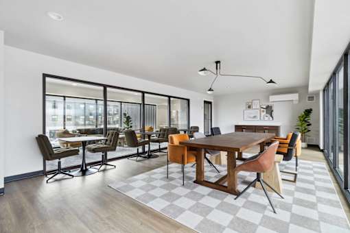 A modern dining room with a large table and chairs.