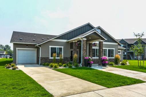 A house with a grey roof and a white garage door.