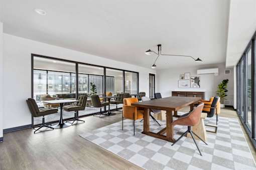 A modern dining room with a large table and chairs.