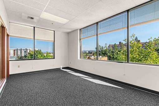 A room with large windows and a view of the city.