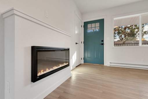 A room with a fireplace and a blue door.