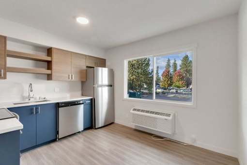 A kitchen with blue cabinets and a stainless steel refrigerator.