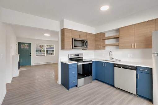 A kitchen with blue cabinets and a white counter.