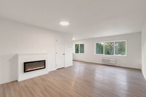A room with a fireplace and wooden floors.