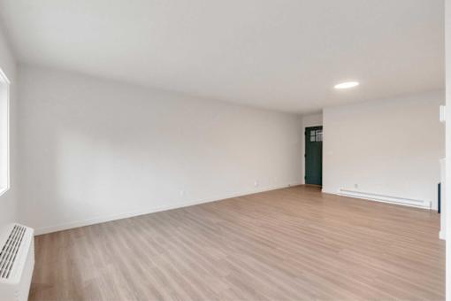 A room with wooden flooring and white walls.
