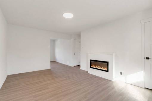 A modern living room with a fireplace and wooden flooring.