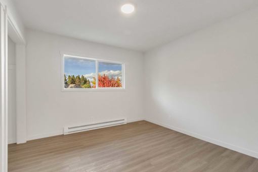 A room with a window and a picture on the wall.