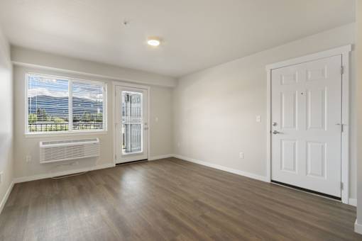 A room with a white door and a window with a view of the mountains.