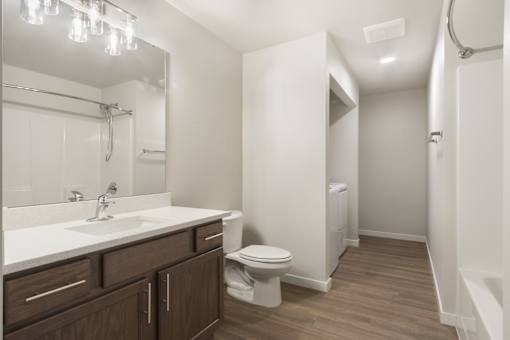 A bathroom with a toilet, sink, and mirror.