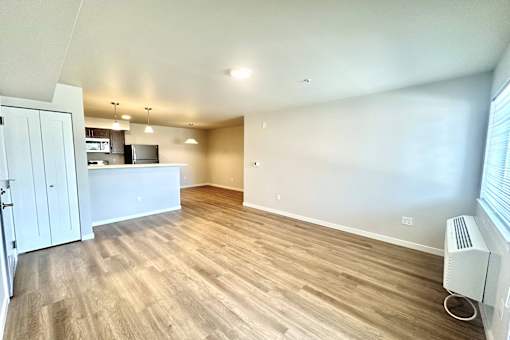 A room with wooden flooring and a white wall.